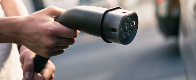 Ladesäule vs. Wallbox wird durch Ladekabel für E-Auto symbolisiert